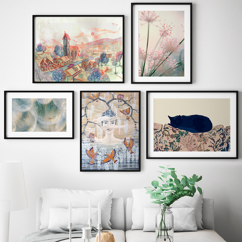 Pared blanca decorada con obras de arte enmarcadas, creando un ambiente artístico y elegante.