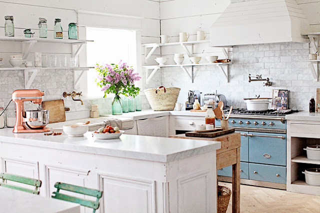 Cocina con encimera blanca y acentos en azul y rosa, creando un ambiente moderno y acogedor.
