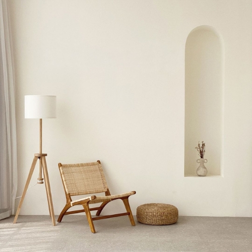 Una silla y una lámpara en una habitación con pared blanca, creando un ambiente 