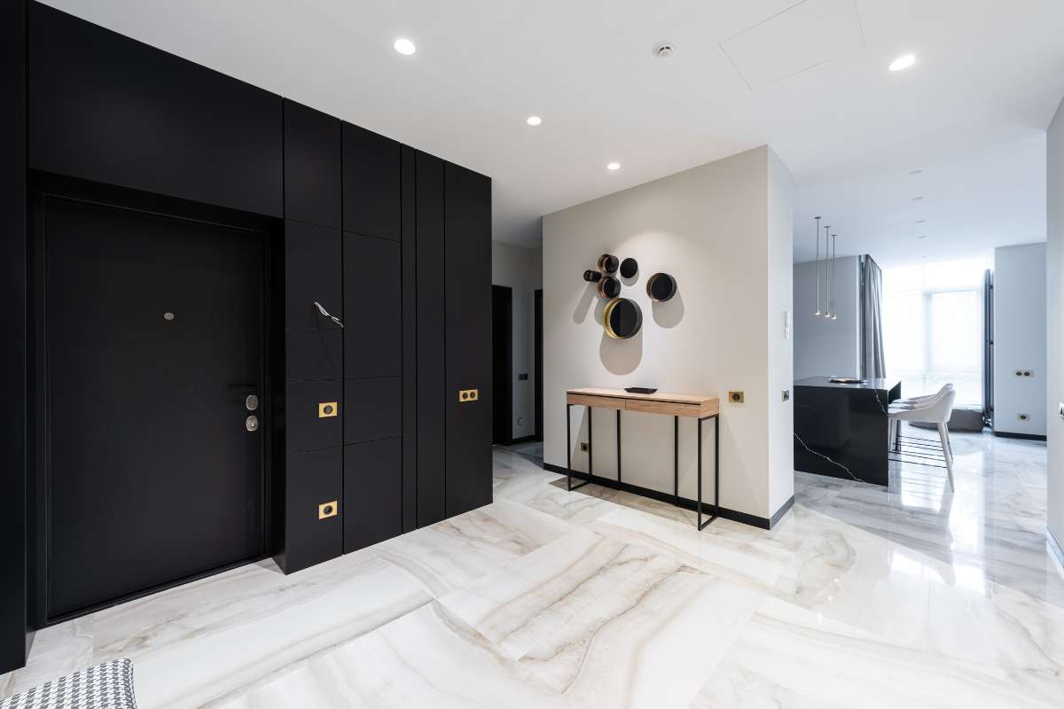 Pasillo moderno en blanco y negro con suelos de mármol, que refleja elegancia y sofisticación en su diseño.