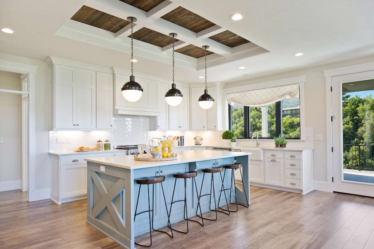 Cocina con gabinetes blancos y suelos de madera, creando un ambiente luminoso y acogedor.