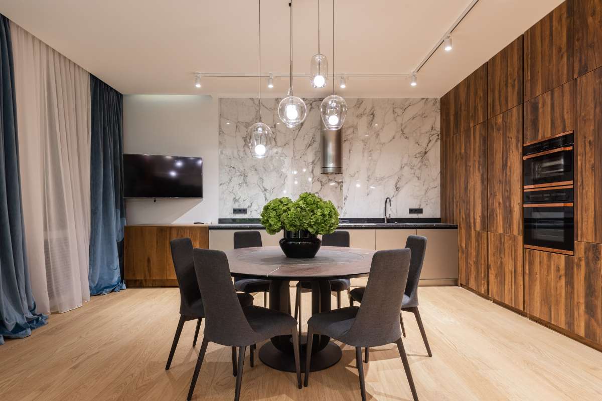 Espacio de cocina contemporáneo con revestimiento de madera y una mesa de mármol, ideal para reuniones familiares.